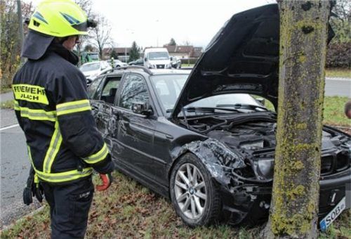 Ein Mitglied der Pullacher Feuerwehr begutachtet das Unfallfahrzeug, das an einem Baum am Pullacher Kreisel zum Stehen gekommen war.