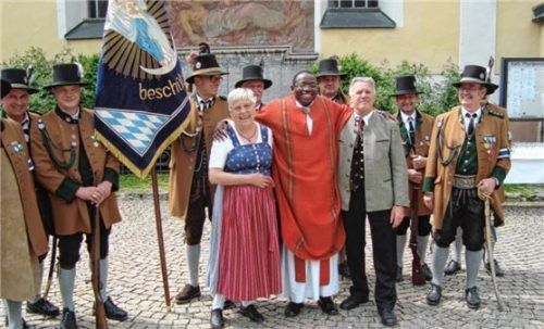 Anna und Albert Bauer mit Pfarrer Dr. Xaver Komba, den das Paar eine Zeit lang bei sich aufgenommen hatte, sowie den Gebirgsschützen aus Raubling.Foto  Archiv Schwitteck