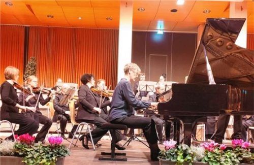 Das Musikkollegium Traunstein unter der Leitung von Augustin Spiel, hier mit der Pianistin Maria Bittel, in der voll besetzten Aula der Berufsschule.Foto  Giesen