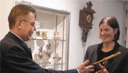 Der scheidende Museumsleiter Walter Leicht überreicht den Amtsdegen des ehemaligen Rosenheimer Bürgermeisters Josef Wüst an seine Nachfolgerin im Städtischen Museum, Andrea Krammer.Foto wunsam