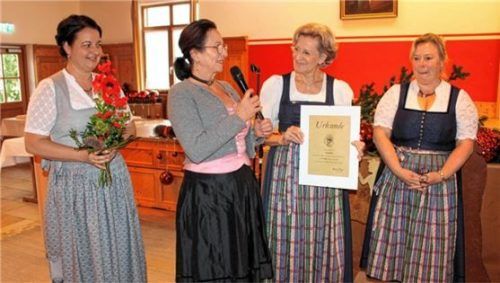 Maria Fischbacher und Katharina Kern (von links) überreichen Agathe Kaffl und Heide Hauser Blumen und Urkunde für 45 Jahre „Landfrauenchor Rosenheim“. Für die musikalische Gestaltung der Adventsfeier sorgte die Chormadlmusi. Foto  Strim