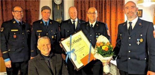 Die Floriansjünger (von links) Joachim Buchmann, Kreisbrandinspektor Martin Gruber und Kommandant Kilian Hager überreichen Markus Steigenberger die Ehrenurkunde. Vorsitzender Sepp Pirchmoser (rechts) und Bürgermeister Hajo Gruber (vorne) freuen sich über das Engagement des Geehrten. Foto  Hoffmann