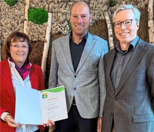 Dritte Bürgermeisterin Gabriele Leicht übergibt die Urkunde an Geschäftsführer Robert Hirzinger (Mitte). Auch Ralf Seeburger, Leiter des Umwelt- und Grünflächenamtes, freut sich über das Engagement der Firma.Foto Stadt Rosenheim