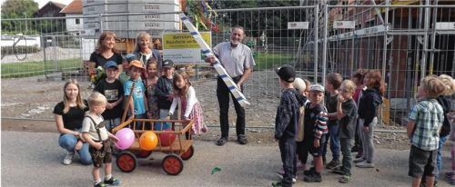 Ehrensache: Die Kindergartenkinder mit den Leiterinnen Elke Döring und Helga Gebler (von links stehend) gaben im Juli den zuvor geraubten Firstbaum schön geschmückt an Bürgermeister Sebastian Winkler zurück. Foto  Jaensch