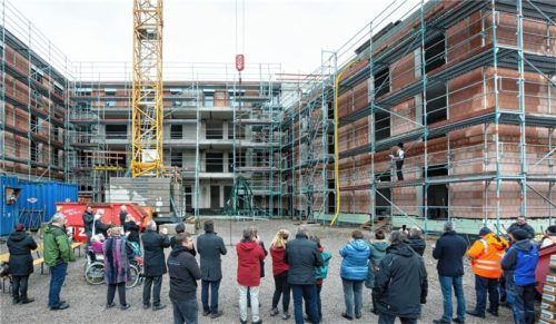 Launiger Richtspruch und kirchlicher Segen am Neubau-Komplex: Rund 40 Gäste waren der Einladung zur Hebfeier auf dem Gelände des Caritas-Altenheims St. Josef an der Bauernberger Straße im Priener Ortsteil Trautersdorf gefolgt. Foto Berger
