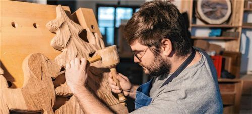 Benedikt Hundhammer schnitzt die neuen Zunfttafeln für den Maibaum. Foto Hundhammer