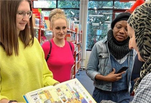 Bibliothekarin Alina Lode führt die Frauen durchs Haus des Buches in Waldkraiburg. Auch fremdsprachige Bücher können sie dort ausleihen, teilweise sogar in ihrer Muttersprache. Foto Helena Gennutt