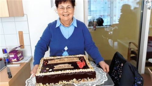 Die ehrenamtliche Organisatorin Gertraud Berger zeigt stolz die Geburtstagstorte.