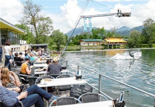 Ein Wasserskifahrer startet genau vor der gut gefüllten Zuschauerterrasse.