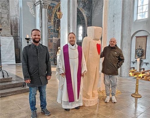 Gruppenbild mit Skulptur: (von links) Bildhauer Marco Bruckner, Pfarrer Rainer Maria Schießler und Mesner Stephan Alof. Foto emk