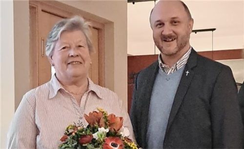 Von Pfarrer David Mehlich gab es neben dem Dank auch Blumen für Aushilfsmesnerin Resi Eder. Foto  Künzner-Hingerl