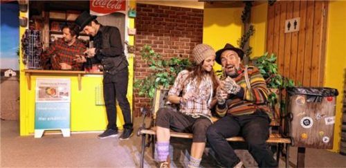 Am Kiosk stehen Kioskbesitzer Standl-Hans (Michael Mittermair) und der geheimnisvolle Giacomo da Capo (Andreas Seidl), während auf der Bank das Landstreicherpärchen Schranken-Susi (Lena Voit) und Weichen-Wastl (Markus Söllner) rasten.Foto Seitz
