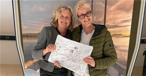 Christiane Lindlacher (links), Leiterin der Tourist-Information, und Künstlerin Stefanie Dirscherl freuen sich über das neue Ausmal-Wimmelbild von Seeon. Foto Gemeinde Seeon-Seebruck