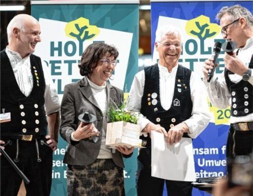 Die beiden Vizepräsidenten, Rolf Rombach (links) und Volker Baumgarten (rechts), ehren den langjährigen Präsidenten von Holzbau Deutschland, Peter Aicher (Zweiter von rechts), auf der Messe „Dach und Holz“ im Beisein seiner Frau Margit.Foto Holzbau Deutschland, Rolando Laube