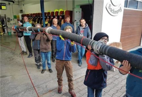 Die Leitung ist noch ein bissel zu schwer, aber mit vereinten Kräften geht es: Seit Herbst gibt wieder eineJugendgruppe in Sachrang.Foto Feuerwehr Sachrang