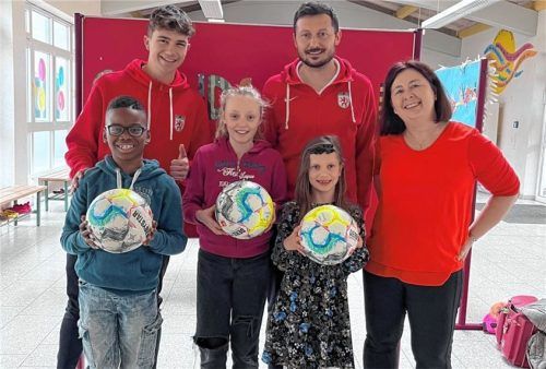 Die Trainer Marinus Savary und Michael Kokocinski mit Schulleiterin Helga Block und drei fußballbegeisterten Schülern.Foto hain