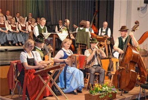 Die Wiesbacher Musikanten spielten frisch auf, im Hintergrund am Tisch führte Sprecher Helmuth Hoch durch den Abend.
