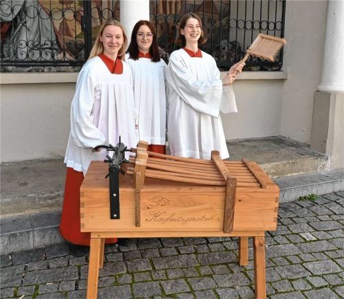 Drei Ministrantinnen spielen die Kastenratsche und die Rasselratsche. Die Kastenratsche wurde 2010 von Ministranten in Prutting angefertigt und wird auch dort verwendet. Foto Schlecker