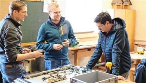 Im Überseer Repaircafé tüfteln (von links) Michael Griesbeck, Ludwig Hafner und ein Besucher an einem großen Fernseher. Foto Repaircafé Übersee