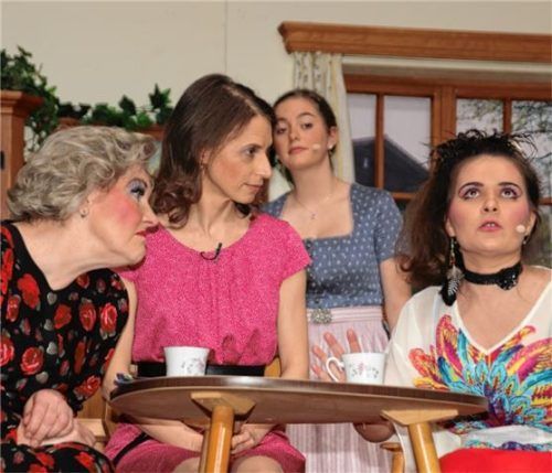 In ihrem Element sind Moni (links, Klara Matzka) und Vroni (rechts, Stefanie Rappolder), die vor der „geheimnisvollen Unbekannten“ (Zweite von links, Elisabeth Pascoe) über das ganze Dorfleben tratschen. Lisa (Regina Huber) lauscht gespannt. Foto Kirsch