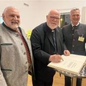 Kardinal Marx trägt sichins Goldene Buch ein