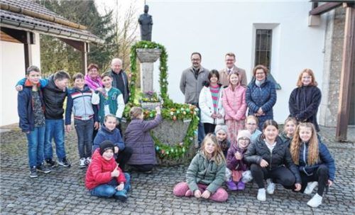 Mit Kindern der Grundschule Schwindegg schmückten (von links) Erwin Ebert und Karl-Michael Dürner vom Kulturverein sowie Bürgermeister Roland Kamhuber und Schulleiterin Susanne Rakobrandt den Osterbrunnen. Foto Sutherland