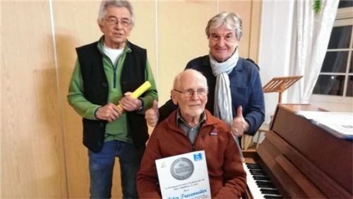 Peter Tresenreiter (vorne) mit der Urkunde für besondere Verdienste, gewürdigt durch den Vorsitzenden des Männergesangvereins, Manfred Panhans (links), und Dirigent Wolfgang Zeller.Foto re