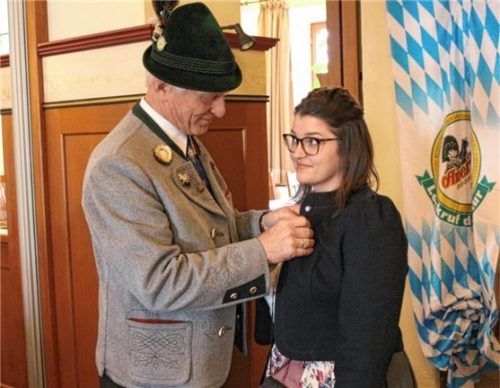 Zum Zeichen der Amtsübergabe steckt Sigi Hundhammer die Brosche des Vorsitzenden Magdalena Osterauer an.Foto re