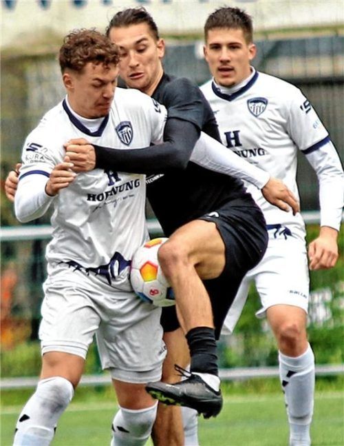 Der Ball ist eingeklemmt: Ampfings Jaume Rubio Gonzalez im Duell mit Jonas Schrimpf.Foto Oliver Rabuser