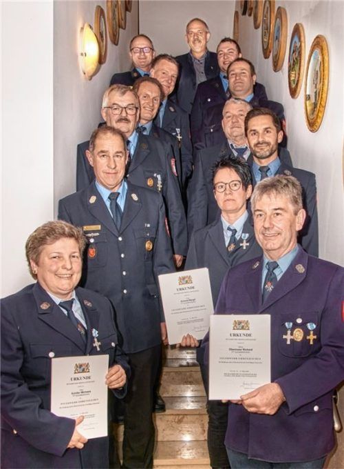 Ehrende und Geehrte (von links treppauf): Michaela Schiller, Kreisbrandmeister Franz Dirnberger, Georg Mitterberger, Hermann Strasser, Franz Oberhauser, Kreisbrandinspektor Werner Hummel, Bürgermeister Josef Eisner, (treppab) Vereinsvorsitzender Georg Lohr junior, Erster Kommandant Christian Wimmer, Johann Gress, Martin Kirchisner, Margit Schmid und Richard Obermaier. Foto Kretschko