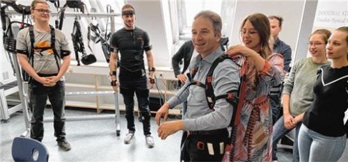 Professorin Franziska Klein, Leiterin des neuen Labors für medizinische Assistenzsysteme, demonstriert ein sogenanntes Exoskelett, das bei körperlichen Tätigkeiten den Körper unterstützt. Foto Anton Maier