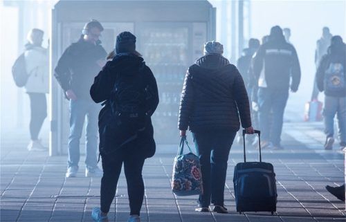 Reisende warten am frühen Morgen auf einem Bahnsteig auf einen Nahverkehrszug.Foto dpa