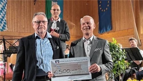 Scheckübergabe von Alois Müller (links) und Sascha Klein vom Gewerbeverein an die Jugendkapelle. Im Hintergrund freuen sich die gut 30-köpfige Jugendkapelle und Rupert Kamhuber am Dirigentenpult. Foto  Kirchner
