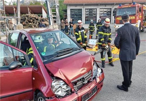 Unter den aufmerksamen Blicken des Prüfers rücken Degerndorfer Feuerwehrleute einem demolierten Auto mit einer Rettungsschere zu Leibe.