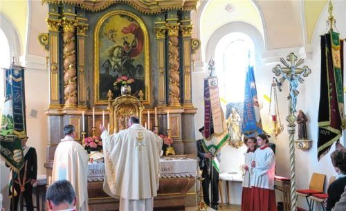 Der Hochaltar war zum Jubiläumsgottesdienst flankiert von den Fahnenabordnungen (von links) der „Glonntaler Schützen“, des Trachtenvereins „d’Haunpoldler“, der Krieger- und Soldatenkameradschaft und der Feuerwehr.