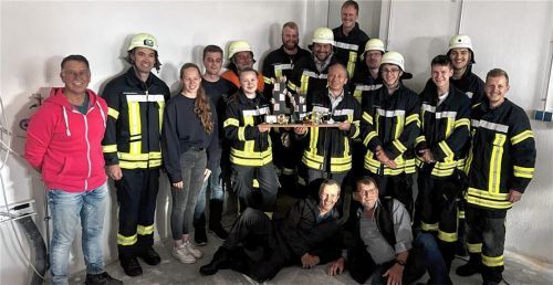 Die Überraschung ist gelungen: Franz Waldleitner (Mitte rechts mit Brett) inmitten seiner Feuerwehrkameraden und Vertretern der Kreisbrandinspektion. Foto re