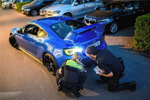 Polizisten kontrollieren ein getuntes Fahrzeug (Symbolbild). Zu einem beliebten Treffpunkt der sogenannten „Autoposer“ hat sich das Herto-Park-Gelände in Kolbermoor entwickelt.Foto  DPA