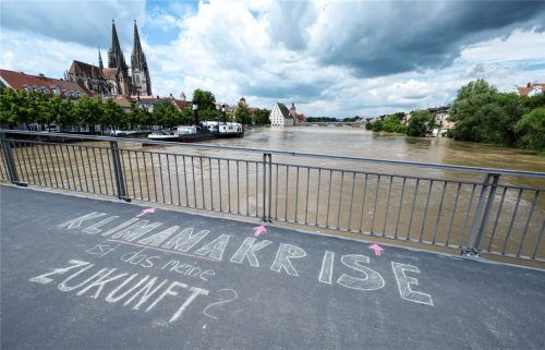 Das Wort „Klimakrise“ ist auf einer Brücke über der Donau in der Regensburger Altstadt zu lesen. „Ist das meine Zukunft?“, fragt der Verfasser.Anfang Juni kämpften Zehntausende Helfer in weiten Teilen Bayerns gegen die Flut und ihre Folgen. Foto dpa