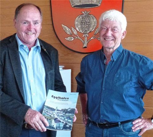 Dieter Gruber (rechts) überreicht Bürgermeister Johann Ziegleder das erste Exemplar des Egglkofener Heimatbuches. Foto Schwarz