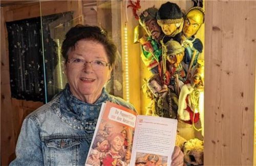 Dorle Dengg mit dem Buch „Puppengeschichten aus Oberaudorf“, das sie dem FWU überlassen hat. Im Hintergrund sind viele der Puppen zu sehen, die in den einzelnen Stücken auftreten. Foto Hoffmann