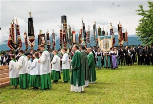 Ein buntes Bild mit stolzen Fahnen der eingeladenen Feuerwehren und Ortsvereine am Feldaltar.