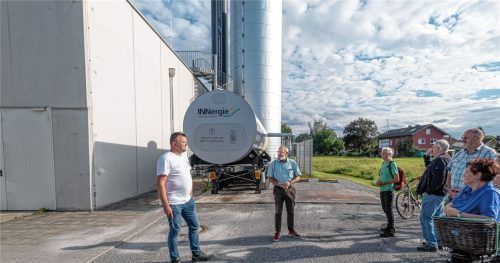 Frank Zillmann von der INNergie (links) und Bürgermeister Peter Kloo (Mitte) mit den Teilnehmern der „Bürgerversammlung vor Ort“. Hinter ihnen der Sattelauflieger mit der Wärme von externen Erzeugern, die zum Blockheizkraftwerk transportiert werden kann. Foto Thomae