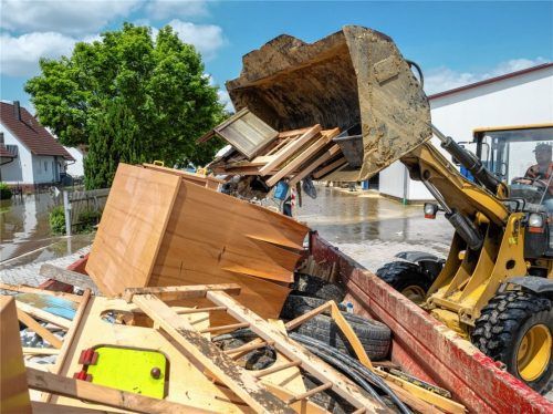 In einem Bauhof wird mit einem Radlader der durch Hochwasser entstandene Sperrmüll in einen Container gekippt. Die deutschen Versicherer fürchten hohe Schäden.Foto Stefan Puchner/dpa