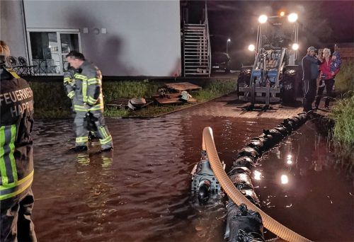 Die Feuerwehr pumpt einen Keller leer. Sandsäcke sollen verhindern, dass das Wasser zurückfließt.