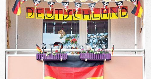 Mit Fahnen, Wimpeln und dem Schriftzug „Deutschland“ ist dieser Balkon an einem Mehrfamilienhaus geschmückt. Foto Jan Woitas/dpa