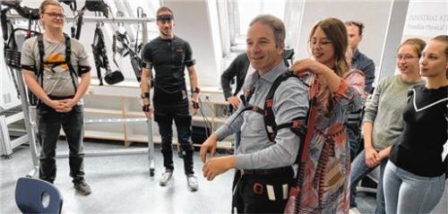 Professorin Franziska Klein demonstriert ein sogenanntes Exoskelett, das bei anstrengenden Tätigkeiten den Körper unterstützt. Foto Anton Maier
