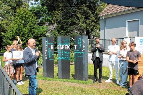 Applaus für ein gelungenes und wegweisendes Kunstwerk mit den Werten Demokratie, Respekt und Vielfalt, enthüllt von Markus Schmidt (links vorne) und Bürgermeister Stephan Schlier (Vierter von rechts).Foto Strim