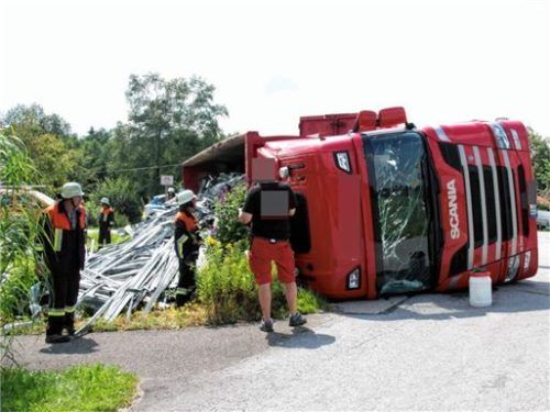 Aus dem umgekippten Laster hat sich der Stahlschrott auf die Wiese neben der Straße verteilt.