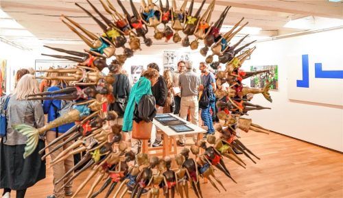 Blick in den Ausstellungsraum im Obergeschoss des Kulturforums durch einen auffälligen Kreis von Barbiepuppen („Strong together Barbies“), den Eva Dahn Rubin geschaffen hat. Auf dem Tisch sind die mithilfe digitaler Technik hinterleuchteten Kohlepapierzeichnungen von Cosima Strähhuber zu erkennen.Fotos effner