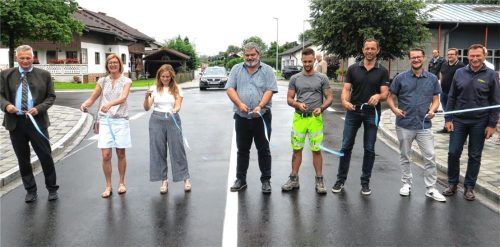 Die Bruckmühler Straße ist wieder befahrbar: (von links) Bürgermeister Richard Richter, Dritte Bürgermeisterin Anna Wallner, Bauamtsmitarbeiterin Ruth Url, Bauleiter Michael Runz, Polier Julien Jakoubek (beide Hans Holzner Baugesellschaft), Markus Bauer (Ingenieurbüro Roplan), Bauamtsleiter Thomas Brückner sowie Konstantin Becker (Technischer Leiter Hans Holzner Baugesellschaft) durchschnitten das Band zur Freigabe. Foto Baumann